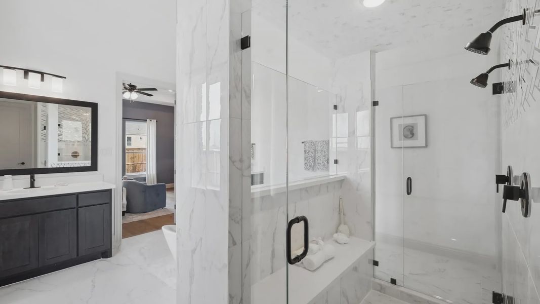 Experience marble elegance with a glass shower and refined wood cabinetry in Westside Preserve.