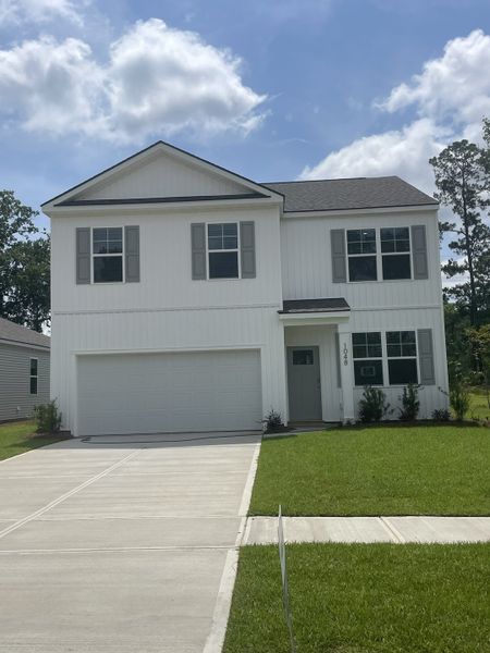 A modern white two-story home with a spacious garage in Pineview North by D.R. Horton (Summerville, SC).