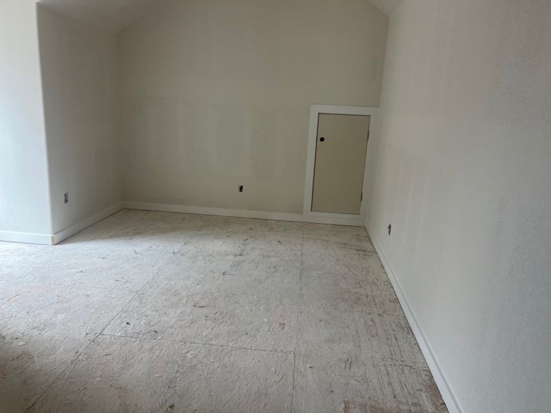 A minimal room with white walls, vaulted ceiling, and an attic access door, ready for finishing touches. A minimal room with white walls, vaulted ceiling, and an attic access door, ready for finishing touches.