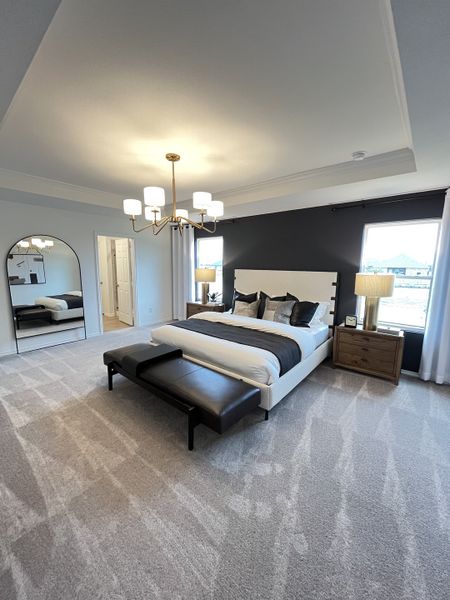 A spacious bedroom with elegant lighting, contrasting accent wall, and plush carpeting creating a cozy yet sophisticated ambiance. A spacious bedroom with elegant lighting, contrasting accent wall, and plush carpeting creating a cozy yet sophisticated ambiance.