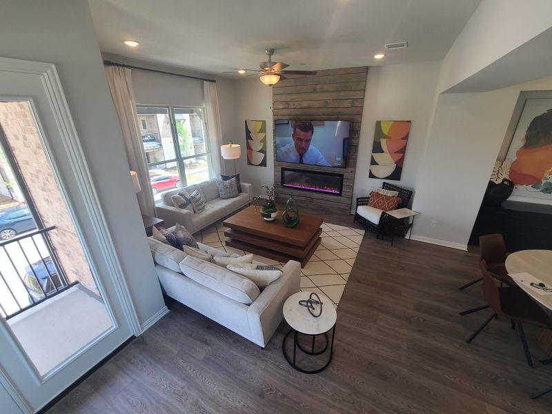 A cozy living room with a sectional sofa, modern fireplace, abstract art, and hardwood floors.