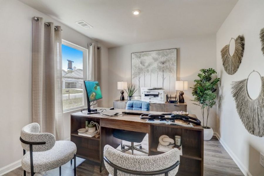 A room with a desk and chairs.