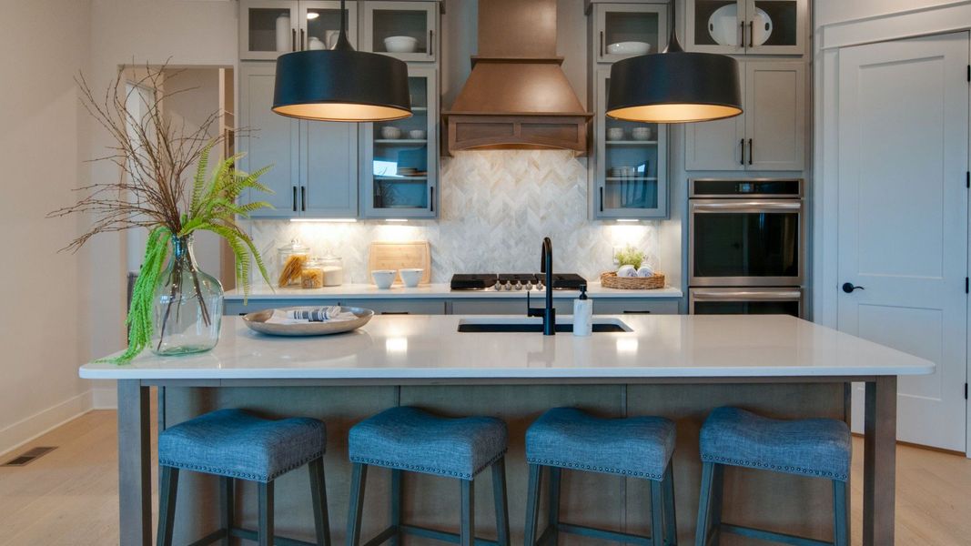 Kitchen with pendant lighting, quartz countertops, and tile backsplash Kitchen with pendant lighting, quartz countertops, and tile backsplash