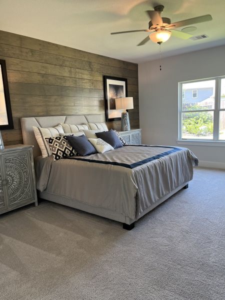 A cozy bedroom featuring a wood accent wall, plush carpeting, and elegant decor elements for a restful retreat.