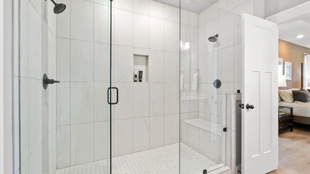 Memorable mornings begin in this elegant primary bathroom with tiled walk-in Roman shower Memorable mornings begin in this elegant primary bathroom with tiled walk-in Roman shower