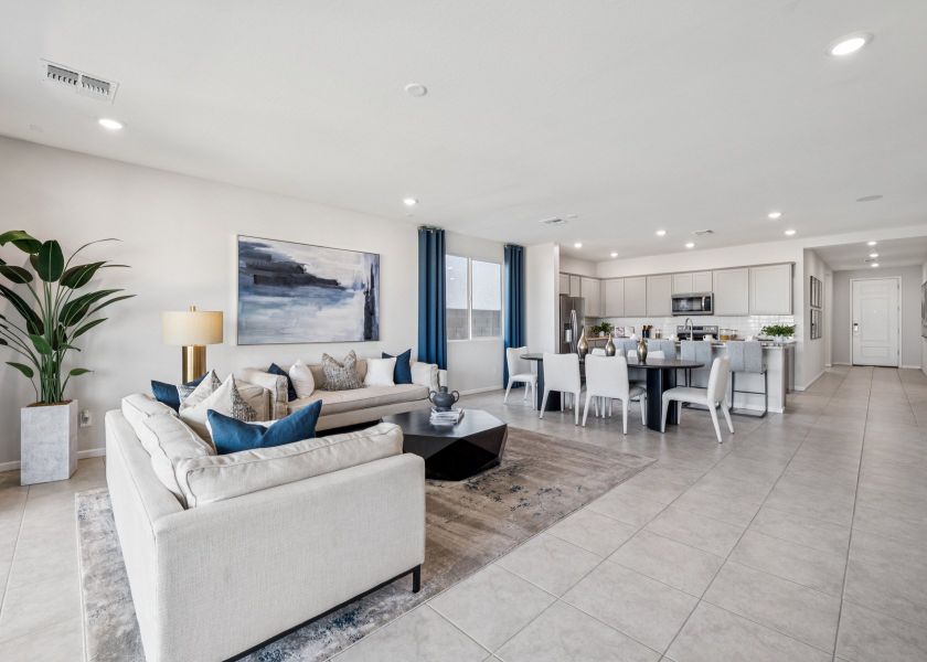 A living room with a white couch and a dining table.