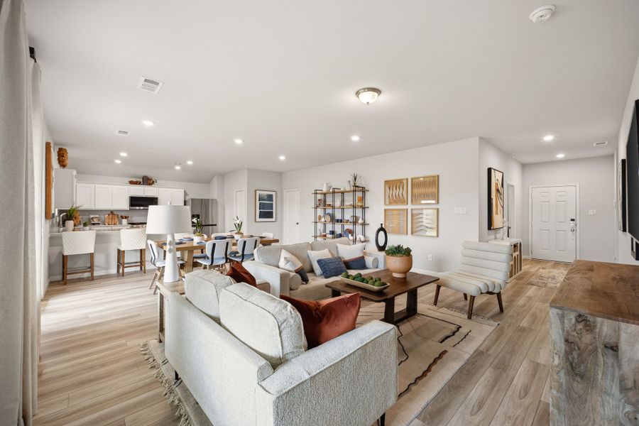 A large living room with a large white couch and a wood floor. A large living room with a large white couch and a wood floor.