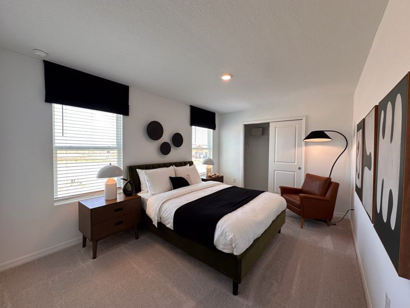 A modern bedroom with a plush bed, sleek furniture, abstract art, and warm lighting.