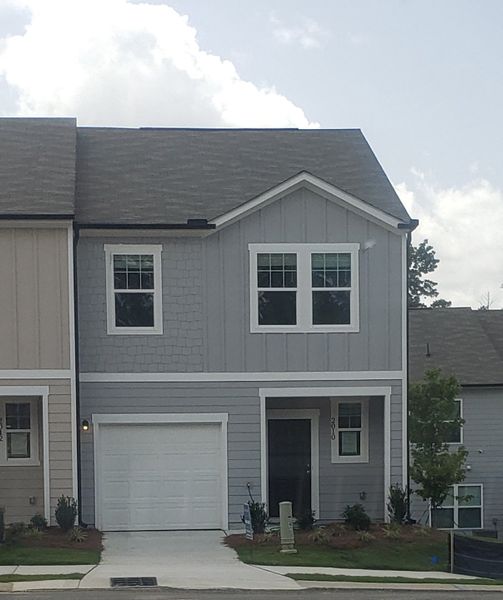 Charming gray home with a manicured lawn in Chestnut Grove by Starlight Homes (Douglasville, GA).