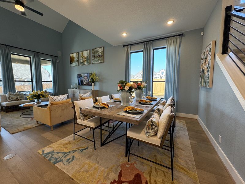 A bright and elegant living-dining area with large windows, cozy seating, and stylish decor. A bright and elegant living-dining area with large windows, cozy seating, and stylish decor.