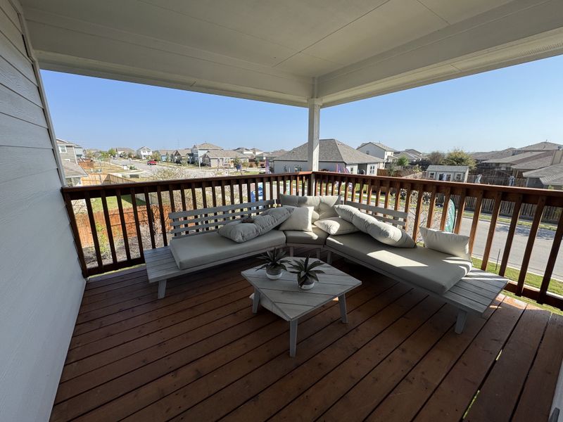 A cozy balcony with cushioned seating, wooden flooring, and community views, perfect for relaxation. A cozy balcony with cushioned seating, wooden flooring, and community views, perfect for relaxation.