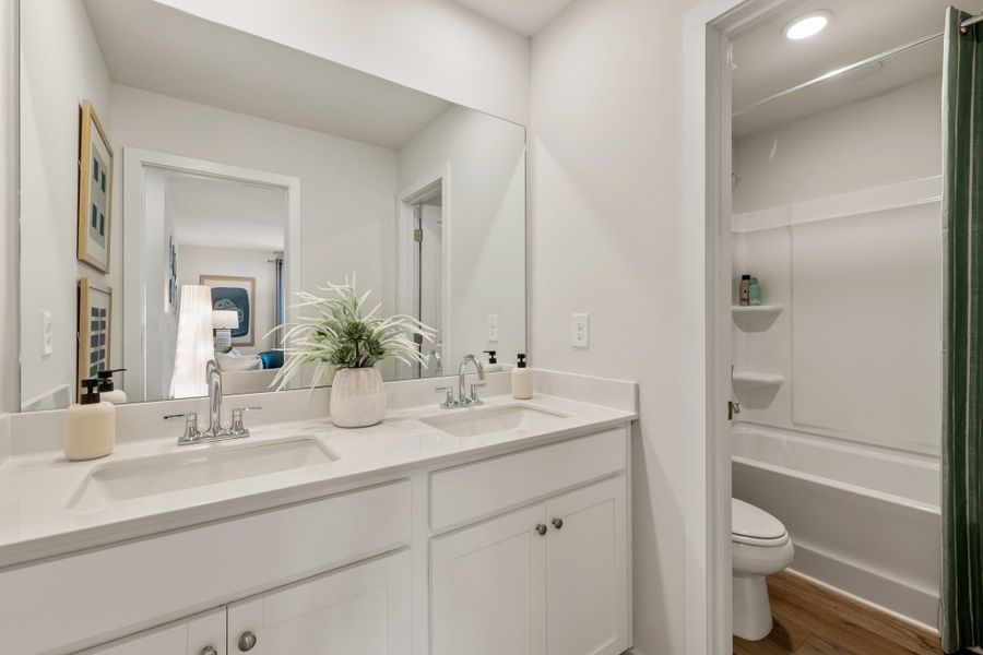 A bathroom with a tub sink and toilet.