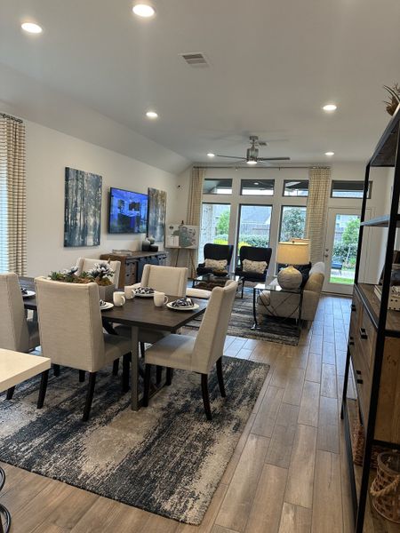 A modern living-dining area featuring elegant decor, large windows, and cozy seating for a stylish and inviting ambiance.
