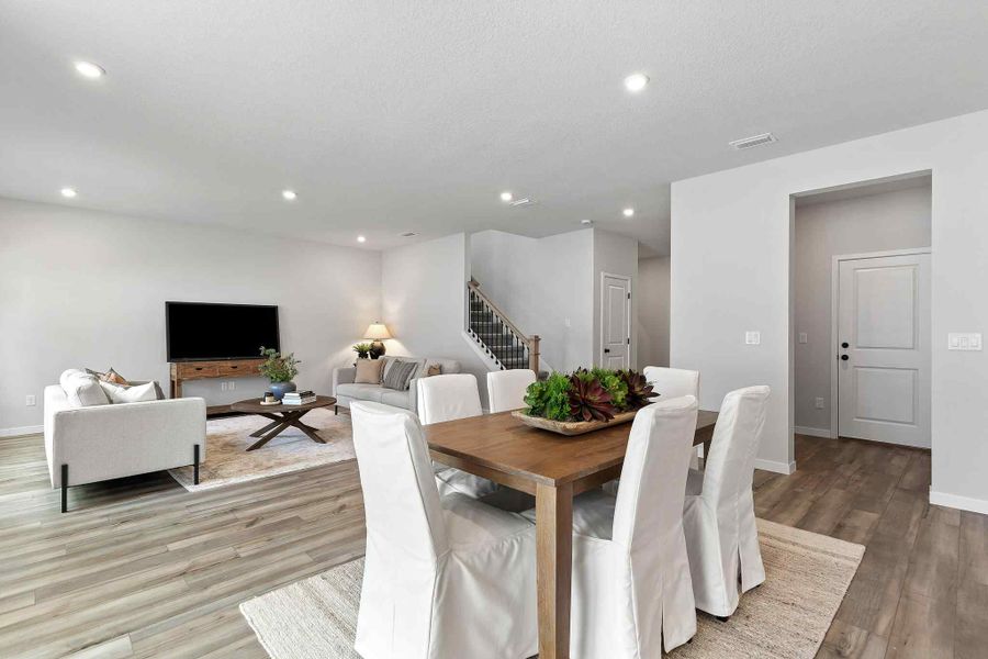 A living room with a table and chairs.