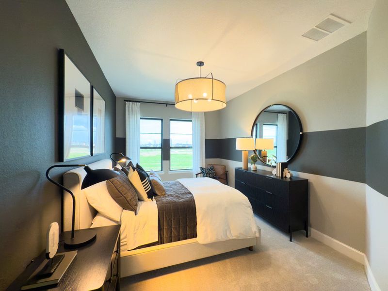 A modern bedroom featuring bold wall accents, cozy bedding, and a large round mirror over a sleek black dresser. A modern bedroom featuring bold wall accents, cozy bedding, and a large round mirror over a sleek black dresser.