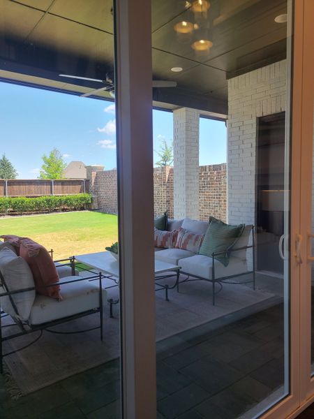 A cozy outdoor patio with comfy seating, ceiling fan, and lush green lawn, perfect for relaxation and entertaining. A cozy outdoor patio with comfy seating, ceiling fan, and lush green lawn, perfect for relaxation and entertaining.