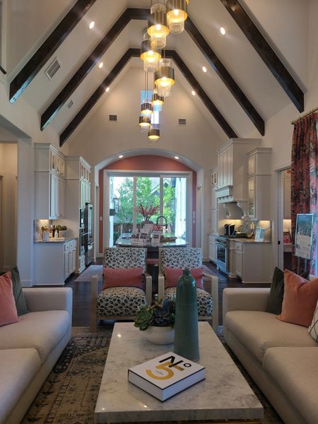 A sophisticated living area featuring exposed beams, chic lighting, patterned chairs, and a cozy atmosphere. A sophisticated living area featuring exposed beams, chic lighting, patterned chairs, and a cozy atmosphere.