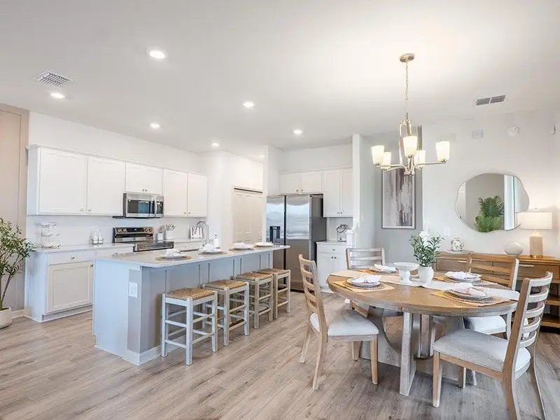 Enjoy a well-appointed kitchen with an island, pantry, and sunny dining space - Aria model home in St. Cloud, FL Enjoy a well-appointed kitchen with an island, pantry, and sunny dining space - Aria model home in St. Cloud, FL
