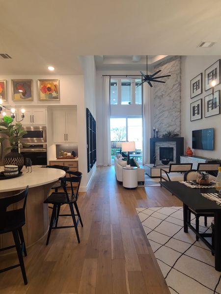 A modern open-concept living space with sleek furnishings, high ceilings, and bright natural light.