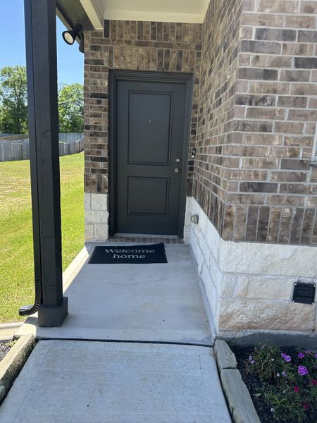 Charming brick entryway with a black door and welcome mat in Chapel Run by Lennar, Montgomery, TX.