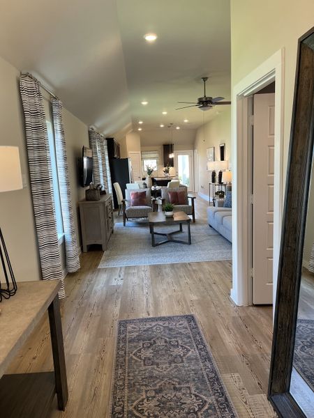An inviting open-plan living space with wood floors, cozy seating, and natural light.
