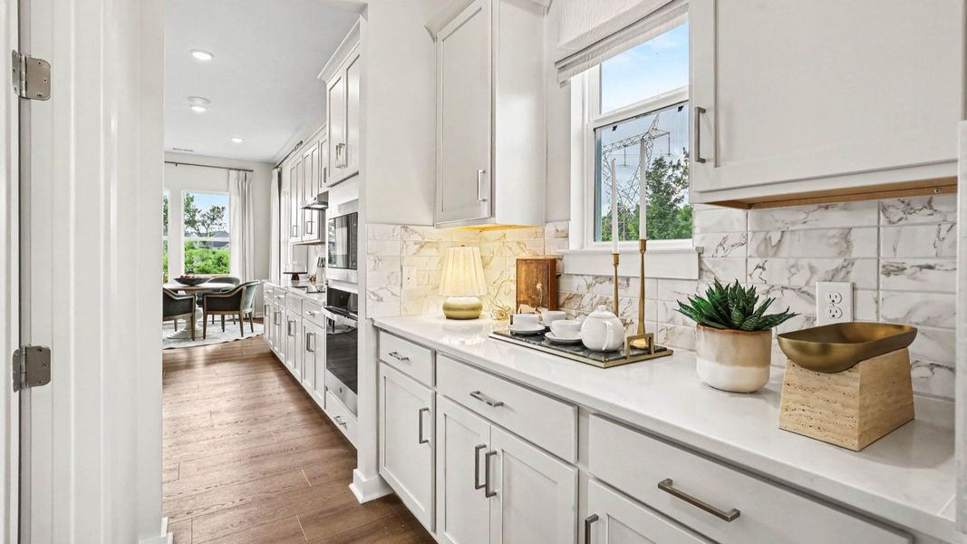 Side portion of kitchen with extra storage space, access to butler's pantry, and tile backsplash Side portion of kitchen with extra storage space, access to butler's pantry, and tile backsplash