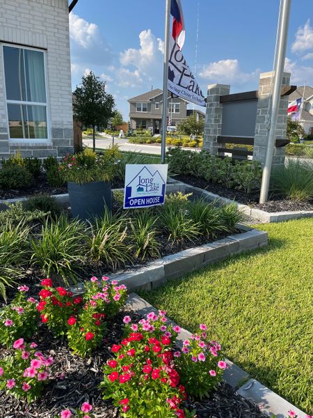 A charming landscaped entrance in River Ranch by Long Lake Ltd. featuring vibrant flowers and modern signage (Dayton, TX). A charming landscaped entrance in River Ranch by Long Lake Ltd. featuring vibrant flowers and modern signage (Dayton, TX).