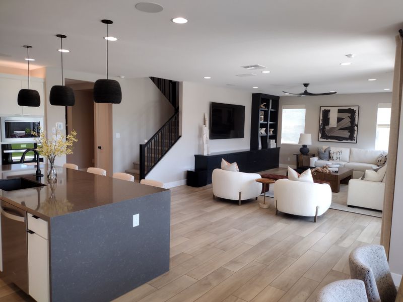 A contemporary living space featuring an open-plan design, sleek kitchen island, cozy seating, and modern decor elements. A contemporary living space featuring an open-plan design, sleek kitchen island, cozy seating, and modern decor elements.