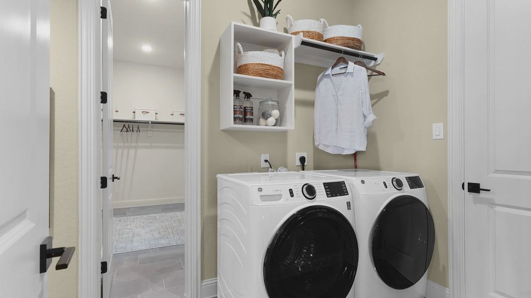 Laundry room with convenient access to the owner’s closet, featuring a functional and well-connected layout.