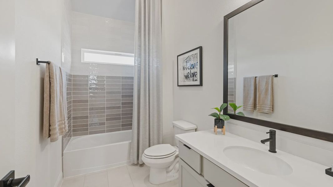 Elegant modern tiles complement a sleek white vanity in Southern Pointe. Experience luxury in every detail.