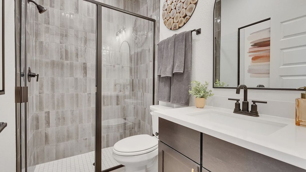 Sophisticated design with sleek glass shower and textured tiles in Spring Creek.