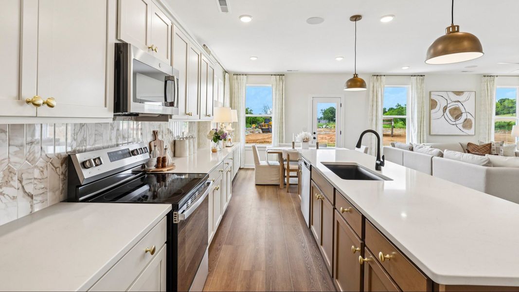 Kitchen with tile backsplash, pendant lighting, and quartz countertops Kitchen with tile backsplash, pendant lighting, and quartz countertops