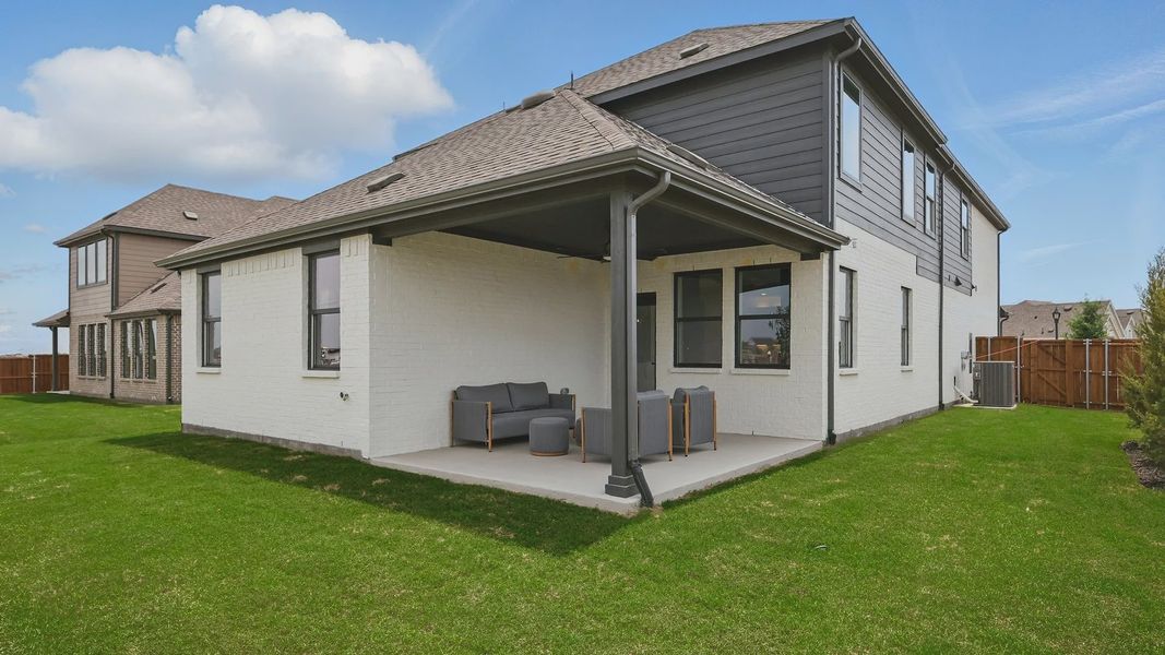 Elegant Westridge home boasts a refined brick facade and chic outdoor living area for luxury living.