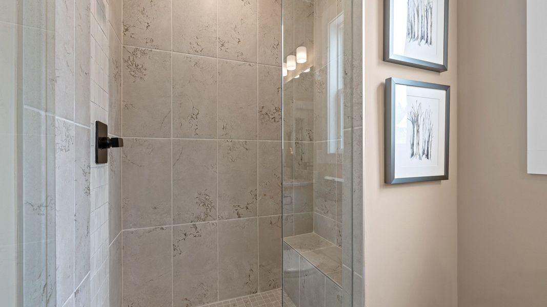 Notable primary bath featuring a glass walk-in shower and tasteful design touches throughout at the Barton Hollow community