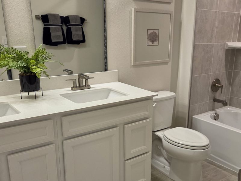 A modern bathroom featuring a dual-sink vanity, sleek fixtures, and elegant tiling. A modern bathroom featuring a dual-sink vanity, sleek fixtures, and elegant tiling.