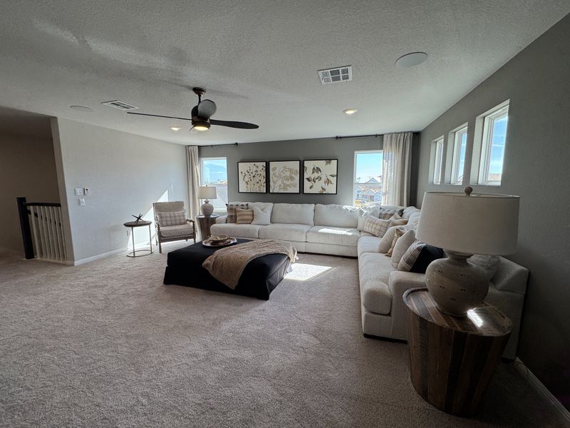 A cozy living room with a large sectional sofa, soft carpet, and ample natural light. Elegant decor enhances its warmth. A cozy living room with a large sectional sofa, soft carpet, and ample natural light. Elegant decor enhances its warmth.