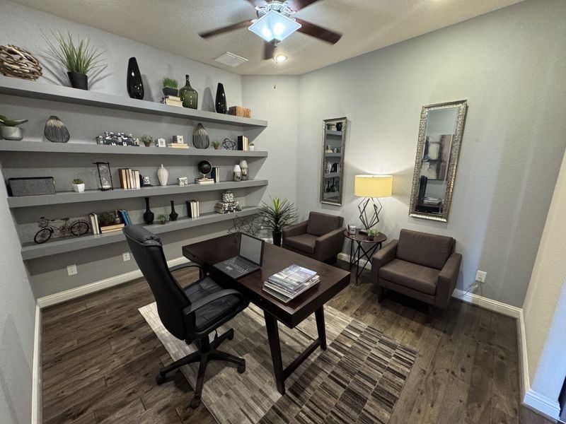 A modern home office featuring sleek shelving, dark wood flooring, and elegant decor for a sophisticated atmosphere.