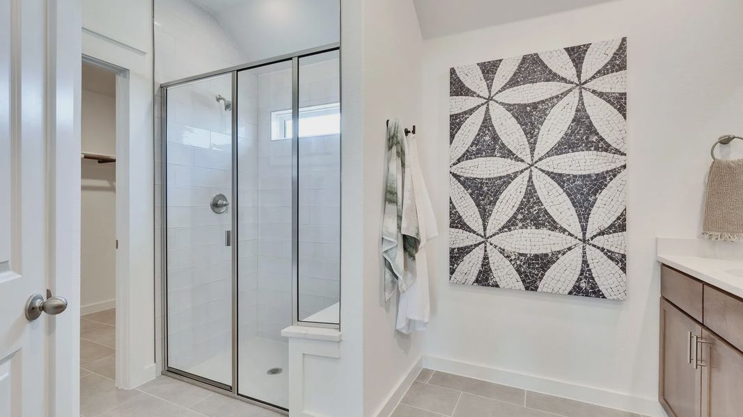 Luxurious bathroom features elegant glass shower, sleek mosaic design, and rich wood cabinetry in Hunters Glen. Luxurious bathroom features elegant glass shower, sleek mosaic design, and rich wood cabinetry in Hunters Glen.