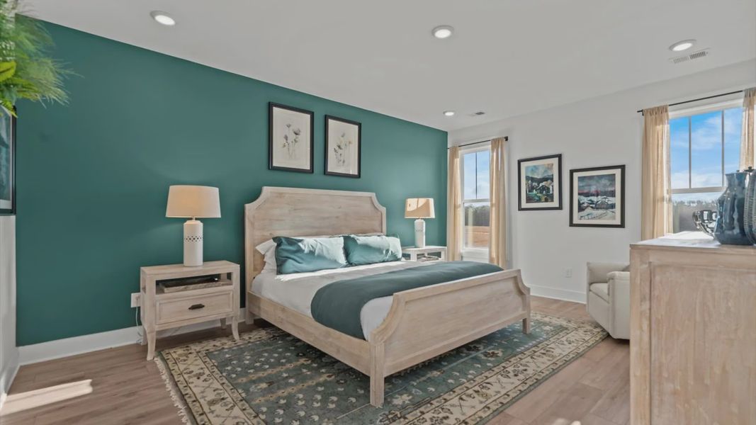 Serene primary suite with green accent walls and hardwood flooring at DRB Homes' Pelham Crossing in Greenville, SC