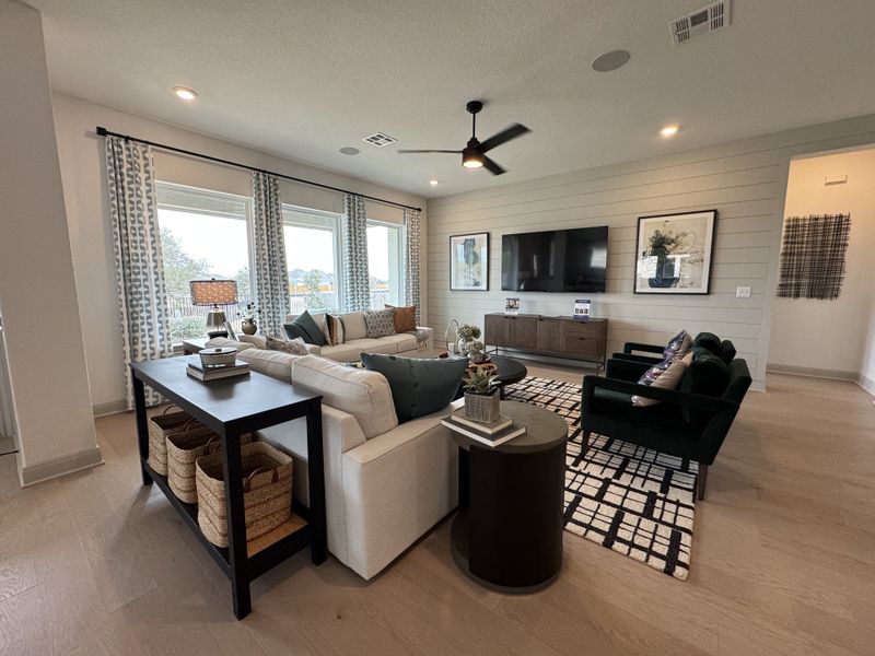 A stylish living room with cozy seating, large windows, a sleek TV setup, and chic decor elements.