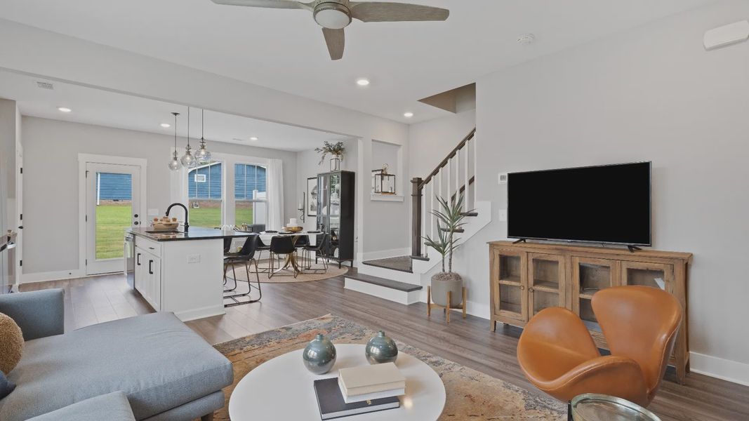 Spacious hardwood flooring family room with large windows and ceiling fan at Barton Hollow by DRB Homes in Fountain Inn, SC