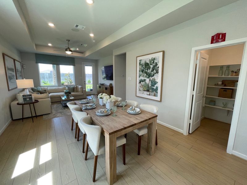 A cozy living and dining space with light wood flooring, modern decor, and ample natural light.