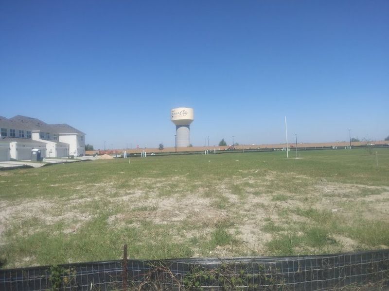 Expansive green field with a distant water tower in Lago Mar by M/I Homes (La Marque, TX). Expansive green field with a distant water tower in Lago Mar by M/I Homes (La Marque, TX).
