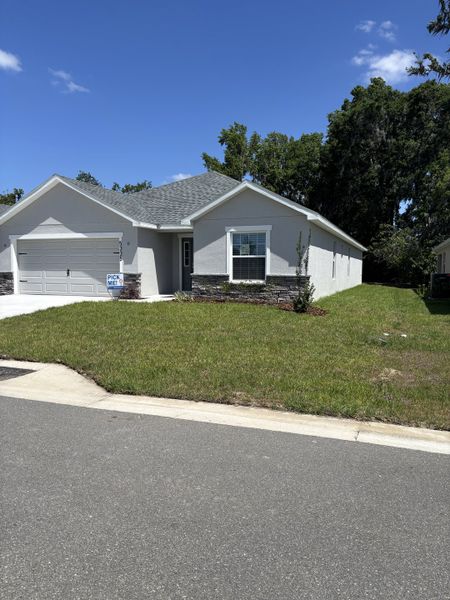 A charming modern home with a manicured lawn in Bennah Oaks by Highland Homes of Florida (Belleview, FL).
