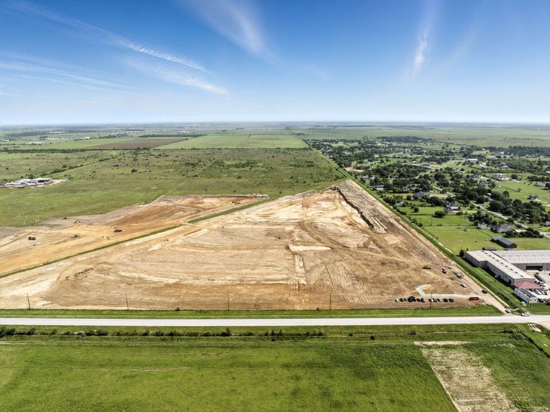 A large field with buildings and trees.