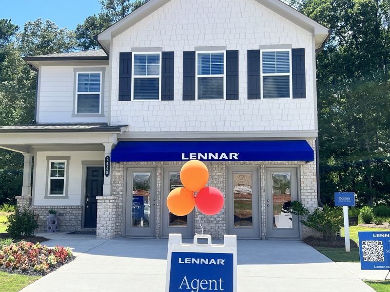 A charming white home with black shutters and a landscaped entry in Millers Pointe by Lennar (Conyers, GA).