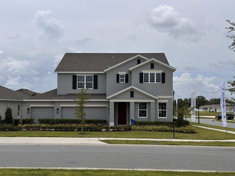 A charming gray two-story home with black shutters and manicured landscaping in Trinity Lakes by Landsea Homes (Groveland, FL). A charming gray two-story home with black shutters and manicured landscaping in Trinity Lakes by Landsea Homes (Groveland, FL).