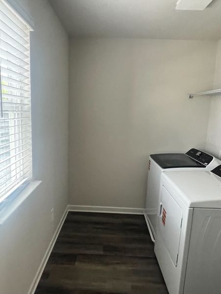 A bright laundry room with modern appliances, vinyl flooring, and ample natural light filtering through the blinds. A bright laundry room with modern appliances, vinyl flooring, and ample natural light filtering through the blinds.
