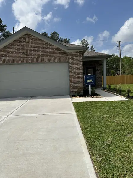 A charming brick home with a spacious driveway in The Landing by K. Hovnanian® Homes (New Caney, TX).