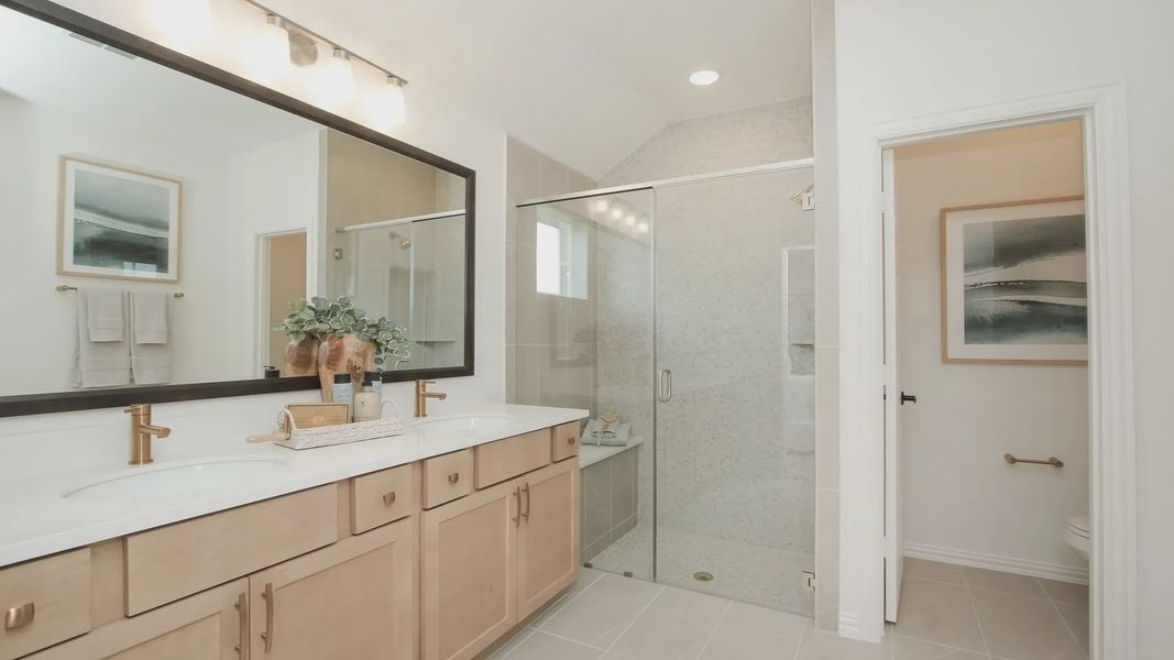 Spacious bathroom with chic dual sinks, elegant glass shower, and refined tilework in Ellis Cove community. Spacious bathroom with chic dual sinks, elegant glass shower, and refined tilework in Ellis Cove community.